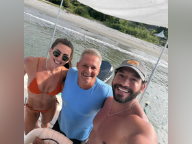 A cheerful group poses for a selfie on a boat, capturing a fun moment by the beach — perfect for memorable outings and celebrations on the water.