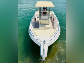 Aerial view of a center console boat with a captain at the helm, navigating through clear waters — perfect for fishing or leisure outings.