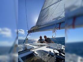 Two friends enjoy a sunny day sailing on the ocean, capturing the essence of adventure and camaraderie on the water.