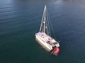 Aerial view of a sleek catamaran docked in calm waters, showcasing its elegant design and spacious layout, perfect for sailing adventures.