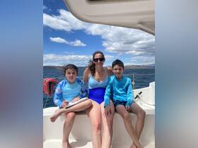 A mother and her two children enjoy a sunny day on the boat, creating lasting memories on the open water.