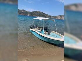 A speedboat rests on the sandy shore, surrounded by clear blue waters and scenic hills in the background, perfect for a day of exploration.
