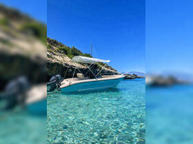 A sleek speedboat anchored in crystal-clear turquoise waters, showcasing the perfect setting for a day of relaxation and adventure on the water.