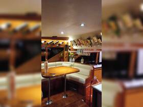 Interior view of a boat's cabin featuring a cozy seating area and a well-stocked bar, perfect for entertaining guests while cruising.