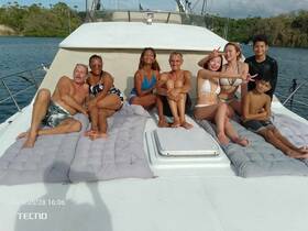 A joyful group enjoys sunbathing on the deck of a yacht, capturing a memorable moment together — perfect for family outings or celebrations on the water.