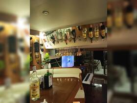 An inviting interior view of a boat's bar area featuring a variety of spirits and a cozy seating arrangement, perfect for entertaining guests while cruising.