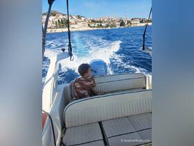 A young boy enjoys the ride on a boat, with a picturesque coastal town in the background — a perfect snapshot of family adventures on the water.