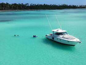 A vibrant scene of people enjoying the turquoise waters, with a boat anchored nearby — perfect for a fun day of swimming and tubing.