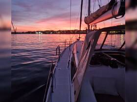 A serene sunset view from the deck of a sailboat, showcasing the tranquil waters and vibrant sky — perfect for evening cruises.