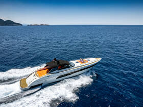 A stylish yacht cruises through the deep blue ocean with a couple enjoying the sun on the deck, perfect for a luxurious day on the water.