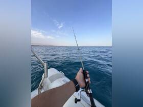 A person holds a fishing rod while enjoying a day on the water, capturing the essence of fishing adventures and outdoor experiences.