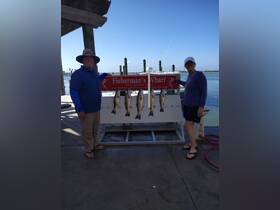 A couple proudly displays their catch of the day at Fisherman's Wharf in Port Aransas, Texas — a perfect moment for fishing enthusiasts.
