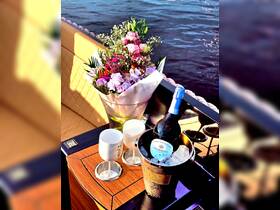 A beautifully arranged display of flowers and sparkling wine on a luxurious boat, perfect for celebrations and special occasions on the water.