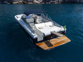 A stunning aerial view of a sleek speedboat docked in crystal-clear waters, showcasing its elegant design and spacious seating area, perfect for luxurious outings.