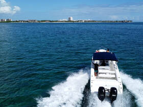 A speedboat glides through clear waters, with passengers enjoying the ride against a scenic coastal backdrop — perfect for adventure seekers and water enthusiasts.