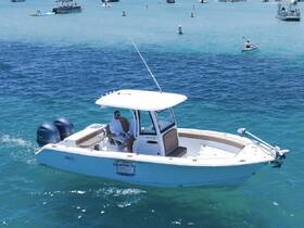 A man relaxes on a boat cruising through clear turquoise waters, showcasing the perfect day for boating adventures.