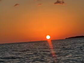 A stunning sunset over the water, creating a picturesque backdrop for evening boat adventures.