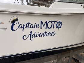 Close-up of the 'Captain MOT Adventures' name on the side of a boat, showcasing its branding and nautical theme.