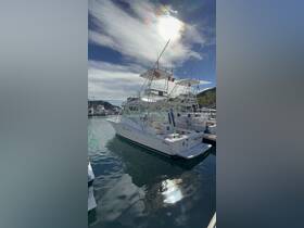 A sleek yacht named 'MAD DASH' docked in a marina, showcasing its elegant design and surroundings under a bright sky.