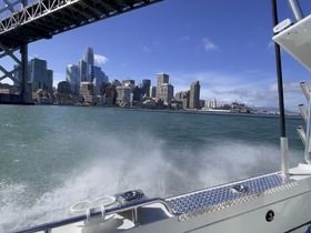 A scenic view of San Francisco's skyline and the Bay Bridge from a boat, capturing the essence of a vibrant city experience on the water.