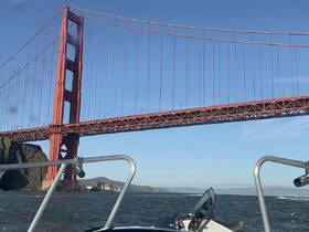 A stunning view of the Golden Gate Bridge from a boat, showcasing the iconic landmark against a clear blue sky — perfect for sightseeing and memorable boating experiences.