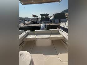 Interior view of a boat's seating area, showcasing comfortable cushions and a clean deck, ideal for relaxing while on the water.