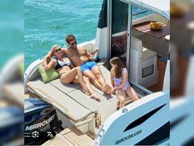 A family enjoys a relaxing day on a boat, sunbathing and spending quality time together — perfect for summer outings and family adventures on the water.