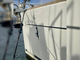 A close-up view of the side of a Beneteau boat named 'Soggy Paws,' showcasing its sleek design and unique silhouette.