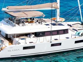 A stunning aerial view of the luxurious Lagoon 620 catamaran 'Akasha' docked in crystal-clear waters, showcasing its elegant design and spacious deck.