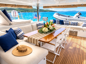 A beautifully arranged interior of a yacht featuring comfortable seating and a dining area, perfect for relaxing and enjoying meals while cruising on the water.