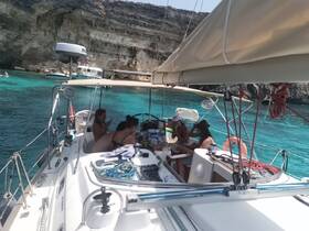 A lively group enjoys a day of sailing and snorkeling on a beautiful turquoise bay, creating unforgettable memories on the water.