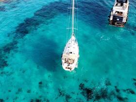 A stunning aerial view of a sailboat navigating through crystal-clear turquoise waters, showcasing the beauty of sailing adventures.