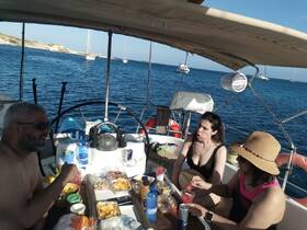 A lively group enjoys a delicious spread of snacks and drinks aboard a boat, perfect for a fun day on the water.