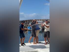 A lively group celebrates on the deck of a boat, spraying champagne in a joyful moment — perfect for capturing memorable occasions on the water.