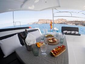 A beautifully arranged dining area on a yacht featuring an array of delicious food and drinks, perfect for a luxurious day on the water.