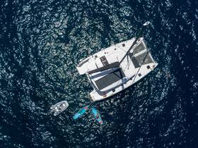 Aerial view of a sleek catamaran surrounded by sparkling blue waters, showcasing its elegant design and perfect for sailing adventures.