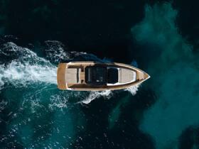 Aerial view of a sleek speedboat cruising through vibrant turquoise waters, showcasing its elegant design and dynamic movement.