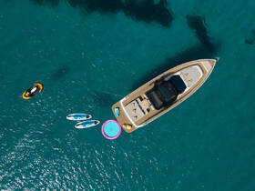 Aerial view of a boat surrounded by paddleboards and an inflatable, showcasing the perfect setup for a fun day on the water.