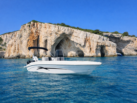 A sleek speedboat glides through crystal-clear waters, with stunning rocky cliffs in the background — perfect for exploring coastal destinations.