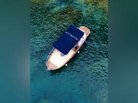 Aerial view of a stylish boat anchored in clear waters, showcasing its elegant design and inviting atmosphere for a day on the water.
