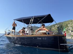 A group of friends enjoys a sunny day aboard a Mimi 6.5 boat, perfect for relaxation and fun on the water.