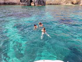 A group enjoys a refreshing swim in crystal-clear waters, perfect for snorkeling adventures and exploring underwater beauty.