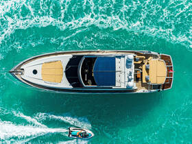 A stunning aerial view of a luxurious yacht cruising through vibrant turquoise waters, showcasing its sleek design and spacious deck.