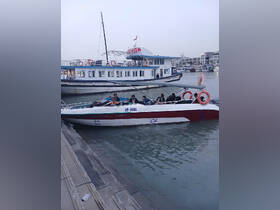 A group of people relaxes on a speedboat docked at the marina, showcasing a vibrant atmosphere perfect for water adventures.