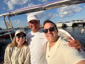 A cheerful group poses for a selfie on a boat, capturing a memorable moment at the marina — perfect for celebrating adventures on the water.