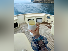 A guest enjoys a refreshing cocktail aboard a boat, showcasing the perfect blend of relaxation and luxury on the water.