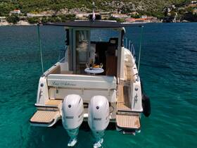 A stunning view of the back of the Lux Aeterna yacht, docked in crystal-clear waters, showcasing its elegant design and inviting atmosphere.