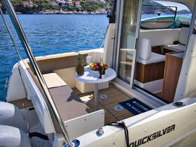 A cozy interior view of a boat featuring a dining area with fresh fruits and champagne, perfect for relaxing and enjoying the scenic waters.