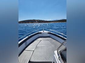 A clear view of the front deck of a boat, showcasing its sleek design against a sparkling blue sea — perfect for enjoying sunny days on the water.