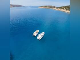 Aerial view of two speedboats cruising through crystal-clear blue waters, showcasing the beauty of a serene coastal landscape.